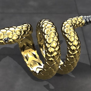 May include: A gold-coloured snake ring with a textured surface. The snake is coiled and has a pointed tail.