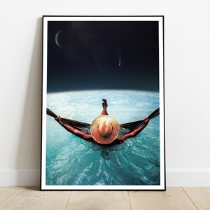 以下が含まれることがあります： フレーム入りアートプリント。水上のハンモックでくつろぐ人物が、麦わら帽子をかぶっています。背景には三日月と彗星が描かれた夜空があり、シュールで夢のような雰囲気を作り出しています。
