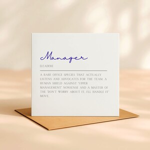 May include: A white card with the word "Manager" in blue cursive script, resting on a brown envelope. The card's text defines a manager as a "rare office species" that listens and advocates.