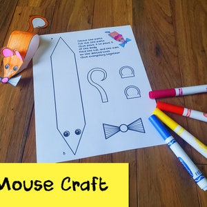 May include: A printable mouse craft template with instructions to color, cut, and glue the parts together. The template includes a mouse body, ears, tail, bow tie, and eyes. The image also shows four markers in red, orange, yellow, and blue.