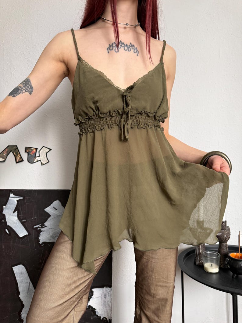K&ouml;nnte beinhalten: Olivgr&uuml;nes Camisole-Top mit Spaghettitr&auml;gern und geraffter Empire-Taille. Der transparente Stoff f&auml;llt locker und erzeugt eine flie&szlig;ende Silhouette. Das Top hat eine zarte Spitzenborte am Ausschnitt.