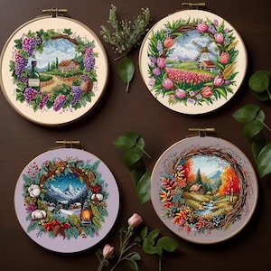 May include: Four embroidery hoop designs featuring floral wreaths with different scenes inside. The top left hoop shows a vineyard with a bottle of wine. The top right hoop shows a windmill and a house. The bottom left hoop shows a winter scene with a lantern. The bottom right hoop shows a forest scene with a stream.