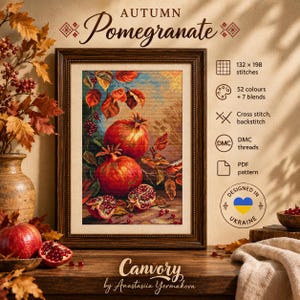 Op de afbeelding: Een ingelijst kruissteekpatroon getiteld Autumn Pomegranate met twee hele rode granaatappels en twee gehalveerde granaatappels met bladeren aan takken. Het ontwerp bevat 132 x 198 steken, 52 kleuren plus 7 mengkleuren en DMC-garens.