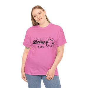 Könnte beinhalten: Pinkes T-Shirt mit einer schwarzen Grafik von Betty White mit dem Text "Just Like a Betty Not a Bully".