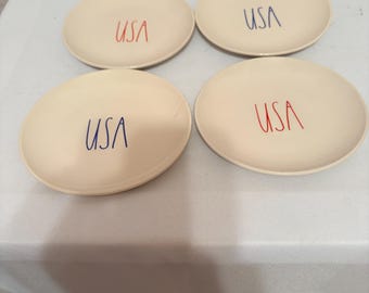 Rae Dunn "USA" themed ceramic plates, commonly used as appetizer or dessert plates, featuring the brand's signature rustic aesthetic.
