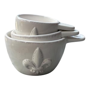 set of three ceramic measuring cups, featuring a Fleur-de-lis design,