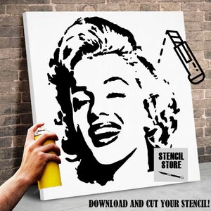 Puede incluir: Plantilla en blanco y negro de la cara de Marilyn Monroe sobre un lienzo blanco. La plantilla está lista para ser recortada y utilizada para un proyecto de arte DIY. La imagen también muestra una lata de pintura en aerosol y un cuchillo artesanal.