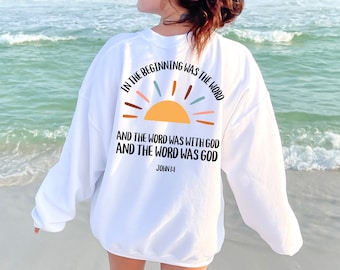 May include: White sweatshirt with a sunrise graphic and the text "IN THE BEGINNING WAS THE WORD AND THE WORD WAS WITH GOD AND THE WORD WAS GOD JOHN 1:1".