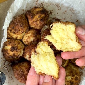 May include: Close-up of freshly baked, golden-brown monkey bread. The bread is torn open, revealing a soft, yellow interior. The exterior is coated in a sweet, cinnamon-sugar crust, perfect for a delicious treat.