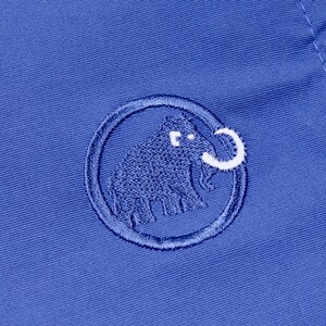 Puede incluir: Primer plano de una tela azul con un logotipo bordado. El logotipo es un c&iacute;rculo con un dise&ntilde;o de mamut lanudo en azul y blanco. La tela tiene una textura sutil y una costura visible.