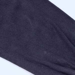 May include: Close-up of a dark navy blue long-sleeved garment. The fabric appears to be a soft knit material, with a slight sheen. The sleeve is gathered at the wrist with a ribbed cuff.