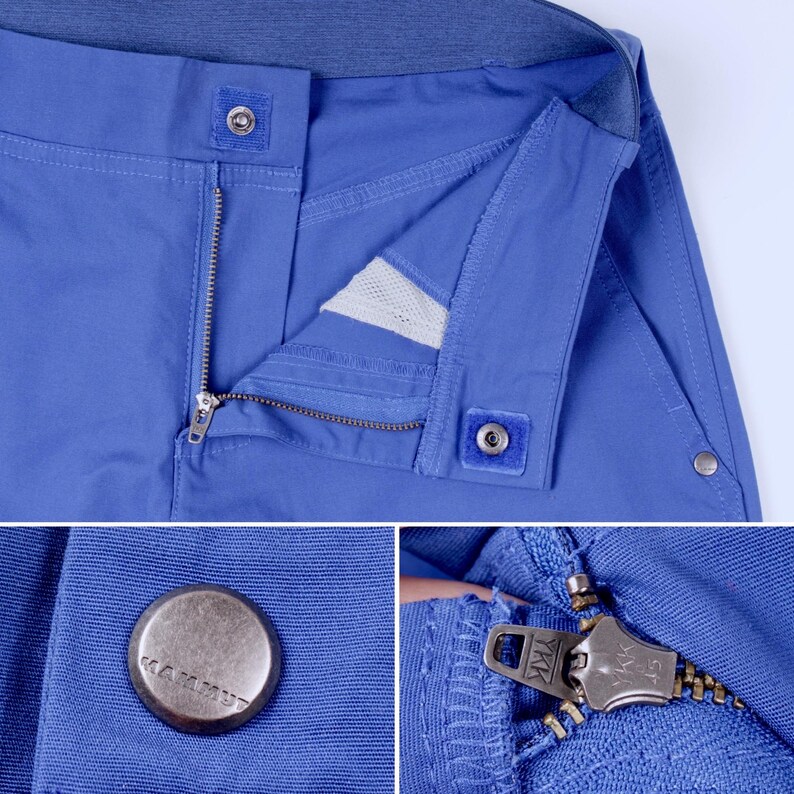 Puede incluir: Primer plano de pantalones azules con cremallera y cierre de bot&oacute;n. Los pantalones tienen un bot&oacute;n met&aacute;lico con la marca "Mammut" y una cremallera YKK. La tela parece ser un material duradero y ligero.
