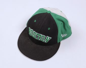 Può includere: Cappellino da baseball nero e verde con visiera bianca e la parola "BOSTON" ricamata in verde sul davanti.