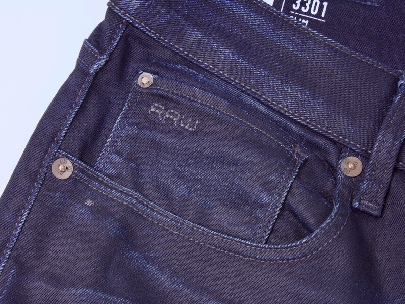 May include: A white ceramic mug with a black handle and the text "But First, Coffee" in a handwritten style. The mug is on a white surface. The mug is approximately 4 inches tall.