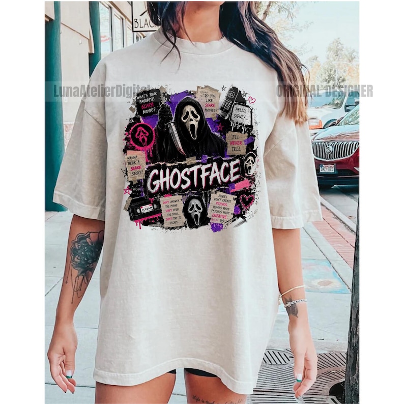 May include: A beige short-sleeve t-shirt featuring a graphic print of the Ghostface character holding a knife. The design includes the text GHOSTFACE, various movie-themed notes, a VHS tape, and purple and black abstract ink splatters.