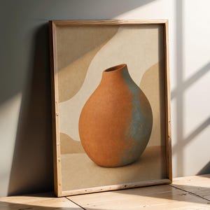 Könnte beinhalten: Ein gerahmter Wandkunstdruck mit einer bauchigen, terrakottafarbenen Vase, die auf einer Seite eine texturierte blau-grüne Patina aufweist. Die Vase ist vor einem Hintergrund aus abstrakten, beigen und ockerfarbenen Kurven in einem hellen Holzrahmen.