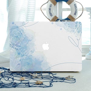 Könnte beinhalten: Eine weiße Laptop-Haut mit einem blauen Aquarell-Design mit zarten floralen Umrissen. Das Design hat ein hellblaues und weißes Farbschema mit einer subtilen blauen Linienzeichnung.