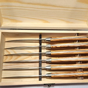 May include: A set of six silver steak knives with olive wood handles in a wooden box.