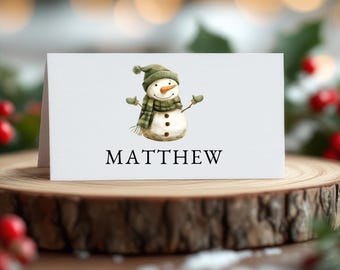 May include: A white card with a snowman illustration and the name "MATTHEW" printed in black.
