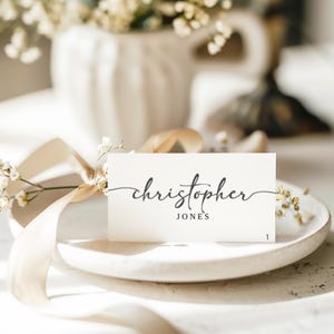 May include: White place card with the name "christopher JONES" written in cursive script.