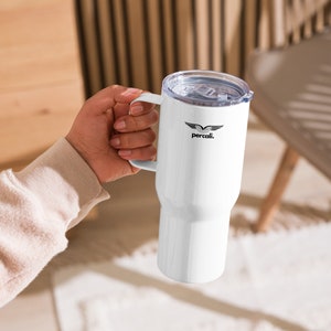 May include: White insulated travel mug with a handle and a clear lid. The mug features a black logo that says "percali." The mug is held by a person.