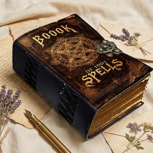 May include: A vintage-style book with the title "BOOOK OF 1001 SPELLS" in gold lettering. The cover features a pentagram design and a metal clasp. The book has a dark brown cover, blue spine, and aged pages, suggesting a mystical theme.