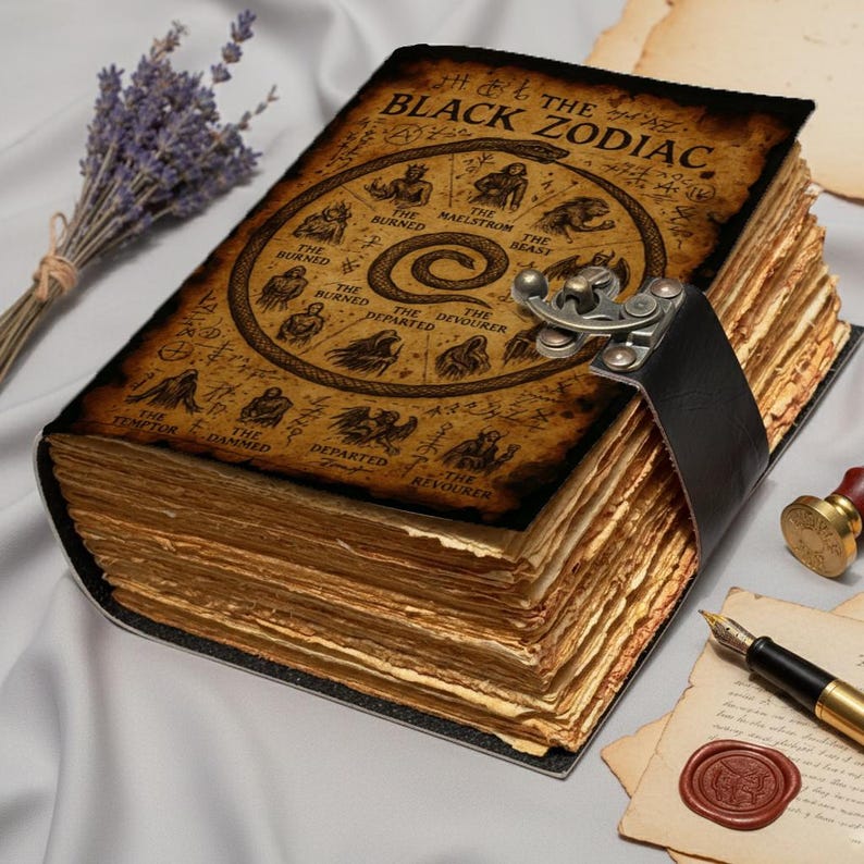 Gothic witchcraft journal with Black Zodiac artwork, aged pages, and decorative clasp strap.