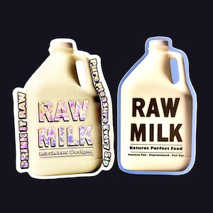 May include: Two white plastic gallon jugs with the words "RAW MILK" printed on them. The left jug has a holographic sticker with the words "DRINK IT RAW" and "Pure Pleasure Every Sip". The right jug has the words "Natures Perfect Food" and "Pasture Fed - Unprocessed - Full Fat" printed below the words "RAW MILK".