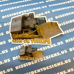 May include: Two yellow and brown bulldozer stickers with the text "Tread on Them" printed on them. The stickers are on a blue background.