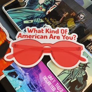 May include: A white sticker with red sunglasses and the text "What Kind Of American Are You?"