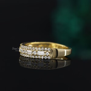 May include: A gold band ring with a row of baguette-cut diamonds and a row of round diamonds.