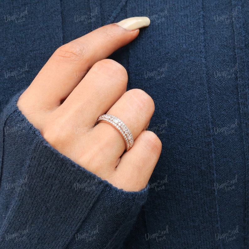 May include: A delicate, double-row diamond eternity band ring with a rose gold setting. The ring features a row of baguette-shaped diamonds and a row of round brilliant diamonds.