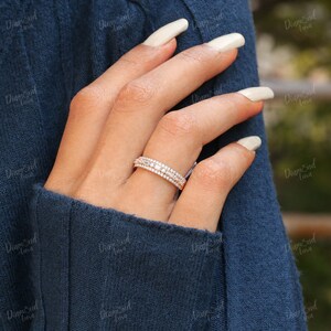 May include: A rose gold band ring with three rows of small round diamonds.