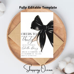 Può includere: Un invito bianco con un fiocco nero e il testo "Cheers to Thirty" e "Join us to celebrate Estella Darcy". L'invito include la data, l'ora e il luogo dell'evento, nonché un numero di RSVP.