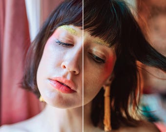 May include: A woman with dark hair and colorful makeup. She is wearing a gold tassel earring.