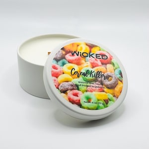 May include: White candle jar with a colorful cereal-themed label. The label reads "All Wicked Up Cereal Killer Scented Wax Candle Hand Poured in Quinton, Netwt 6 oz 170 g."