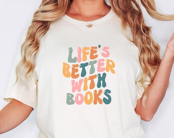 May include: A white t-shirt with a colorful graphic that reads "Life's Better With Books".