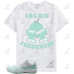May include: White t-shirt with "IGLOO FRESHNESS" text and a mint green graphic of two air fresheners. A pair of white and mint green sneakers is in the foreground. The shirt has a crew neck and short sleeves.