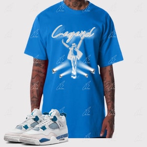 May include: A blue t-shirt with a white silhouette of Michael Jackson with the word "Legend" above him. The t-shirt is paired with white and blue sneakers.