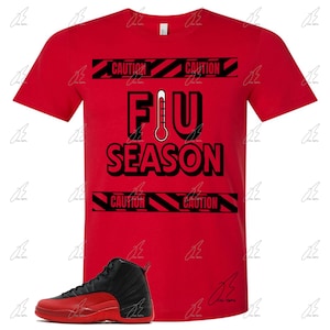 May include: Red t-shirt with black and white text that says "Flu Season" with a thermometer graphic.  The shirt has black and yellow caution tape graphics.  A pair of black and red sneakers are shown below the shirt.