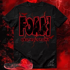 May include: Black t-shirt with the word "FOAM" in large black letters outlined in red, with red lightning bolt designs. The text "GREATNESS IS BACK!!" is below. A matching red and black sneaker is in the image.