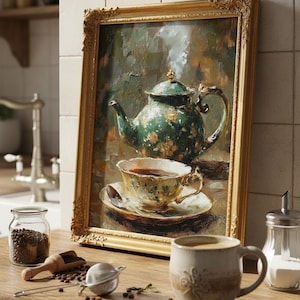 Può includere: Dipinto incorniciato di una teiera e tazza da tè verdi floreali. Una tazza in ceramica, un barattolo di vetro con chicchi di caffè e un infusore per tè sono su una superficie di legno. Il dipinto ha una cornice dorata ornata.