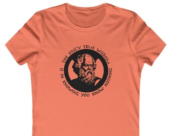 May include: A coral pink women's t-shirt with a black and white graphic of a man's face in a circle. The text around the circle reads "The only true wisdom is in knowing you know nothing."