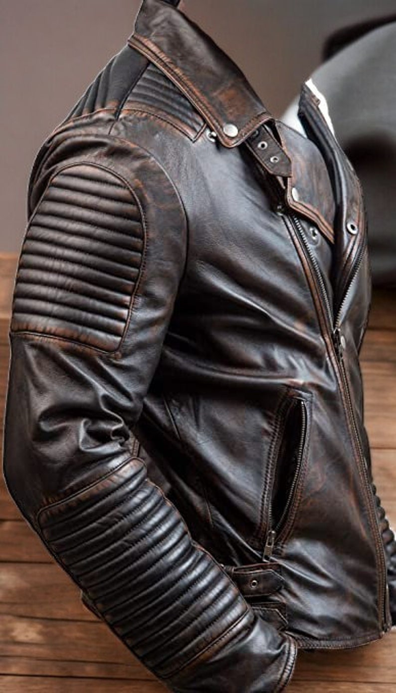 May include: A brown leather jacket with a zip fastening and a quilted design on the sleeves.