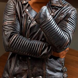 May include: A brown leather jacket with a zip fastening and a quilted design on the sleeves. The jacket has a distressed look and is made of genuine leather.