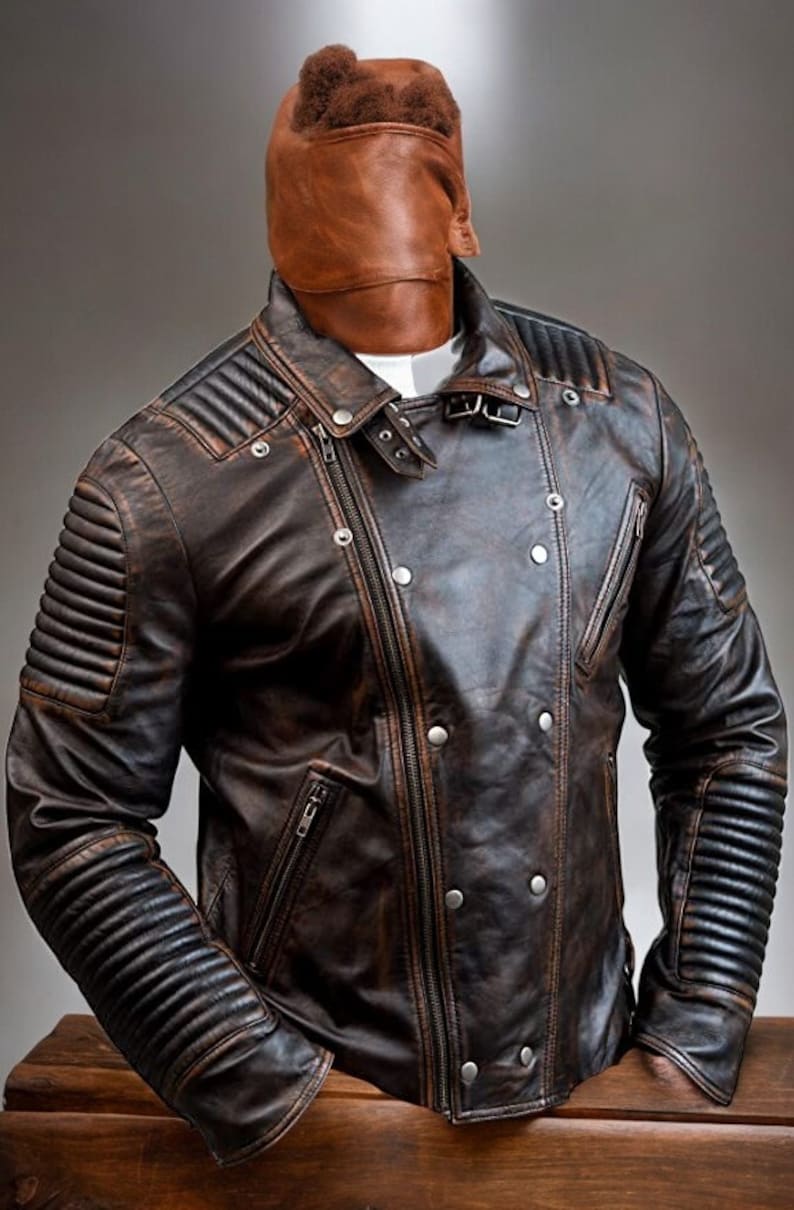 May include: A brown leather jacket with a zip fastening and a distressed look. The jacket has a stand-up collar and a quilted design on the sleeves.