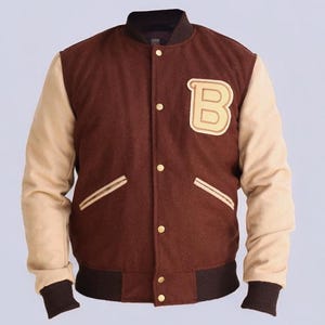 May include: A brown and beige varsity jacket with a large letter "B" on the left chest. The jacket has a ribbed collar, cuffs, and waistband.