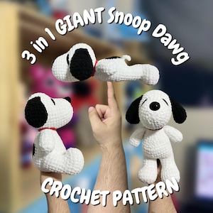 May include: Three white and black crocheted dog figures with red collars, presented in different poses. The text 3 in 1 GIANT Snoop Dawg CROCHET PATTERN is displayed in white arched lettering around the figures, which are held up by hands.