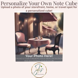 May include: A personalized note cube featuring a cafe scene with a table and chairs. The cube has text that reads "Personalize Your Own Note Cube" and "Your Photo Here!" The logo for Catchy Kitchen is at the bottom.