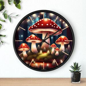 May include: A black wall clock with a round face featuring a whimsical illustration of red and white mushrooms in a forest setting. The clock hands are visible, and the background is a dark blue with glowing lights.